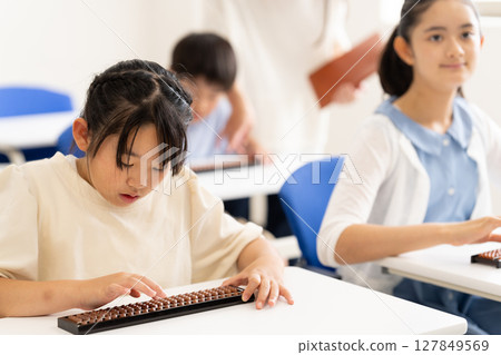 Elementary school students learning abacus Elementary school students learning abacus 127849569