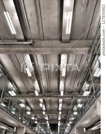 a modern interior industrial design with fluorescent lighting and visible ductwork reflecting a sleek urban style 127850802