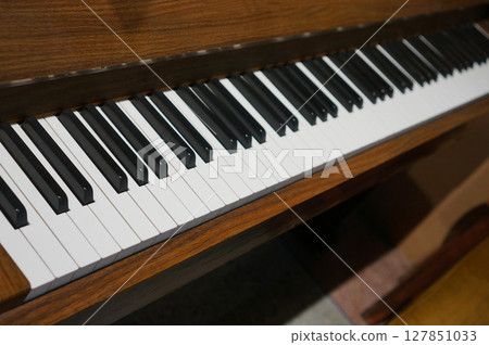 a grand piano keyboard with its ebony and ivory keys, the warm wooden frame 127851033