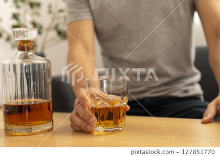 Alcohol addicted man sleeping at the table. Sad depressed male adult having troubles with alcohol. Alcohol addicted man sleeping at the table. Sad depressed male adult having troubles with alcohol. 127851770