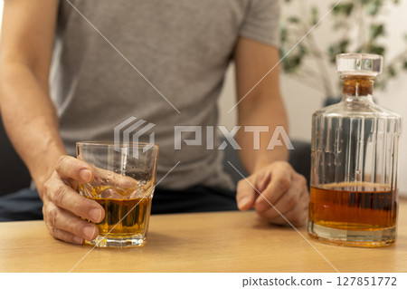 Alcohol addicted man sleeping at the table. Sad depressed male adult having troubles with alcohol. 127851772