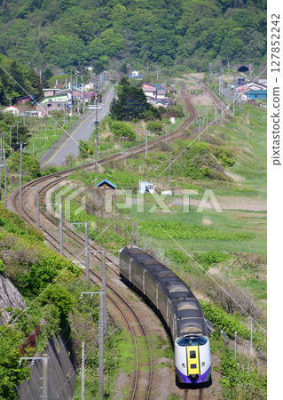 261 series Muroran Main Line Limited Express Hokuto running through a tranquil landscape 127852242