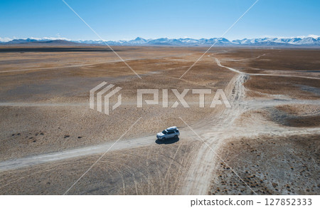 Aerial view of offroad car running on high elevation lakeside Aerial view of offroad car running on high elevation lakeside 127852333