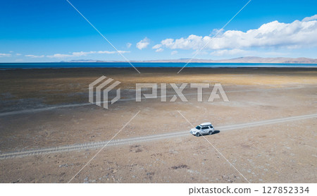 Aerial view of offroad car running on high elevation lakeside Aerial view of offroad car running on high elevation lakeside 127852334