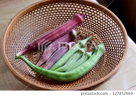 The "Okra" A summer vegetable grown in a home garden in midsummer. Harvested two-colored okra fruit (close-up) The "Okra" A summer vegetable grown in a home garden in midsummer. Harvested two-colored okra fruit (close-up) 127852669