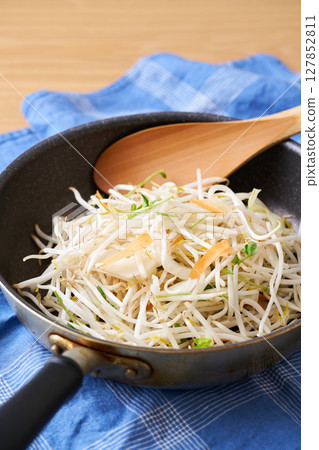 Cut vegetables served in a frying pan. Bean sprouts, pea sprouts, carrots, onions 127852811