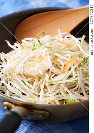 將切好的蔬菜放入煎鍋中。豆芽、豌豆芽、胡蘿蔔、洋蔥 127852812