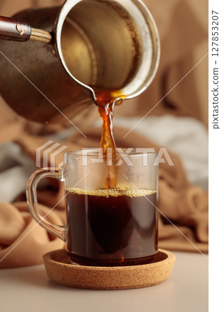 Pour the black coffee into a cup. Pour the black coffee into a cup. 127853207