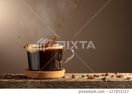 Black coffee in glass cup on a brown background. 127853227