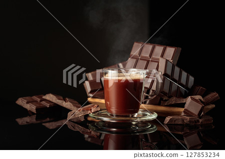 Mug of hot chocolate against broken bitter chocolate bars. 127853234
