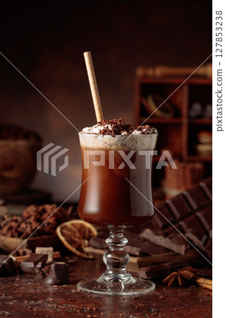 Hot chocolate topped with whipped cream and sprinkled with chocolate chips. 127853238