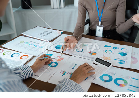 Businesswoman using a calculator to calculate numbers on a company's financial documents, she is analyzing historical financial data to plan how to grow the company. Financial concept 127853842