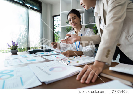 business woman discussing strategy in office. colleagues collaborating on business report 127854093
