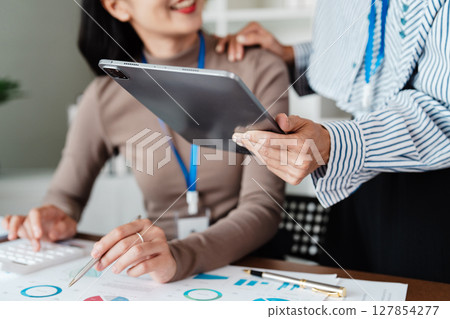 Business colleagues reviewing data on tablet in office. Collaborative business woman meeting hands analyzing financial charts and graphs Business colleagues reviewing data on tablet in office. Collaborative business woman meeting hands analyzing financial charts and graphs 127854277