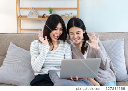 pride month Happy woman lesbian gay lgbt couple using laptop to video call with family, friends. LGBTQ couple concept pride month Happy woman lesbian gay lgbt couple using laptop to video call with family, friends. LGBTQ couple concept 127854366
