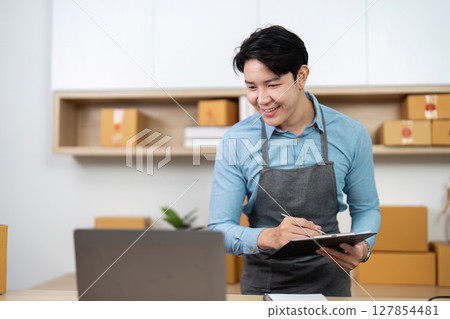 Entrepreneur reviewing inventory on laptop in a modern workspace Entrepreneur reviewing inventory on laptop in a modern workspace 127854481