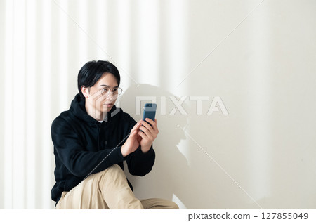 Looking at your smartphone by the wall 127855049