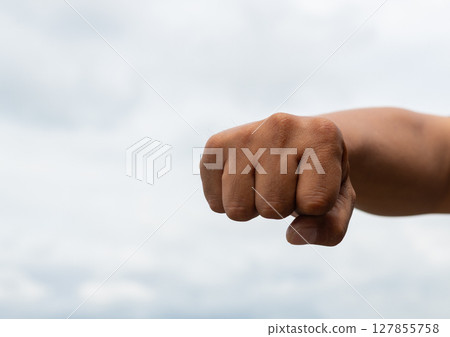 Male hand with a clenched fist Male hand with a clenched fist 127855758
