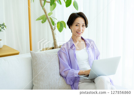Middle-aged woman using a laptop in her room 127856860