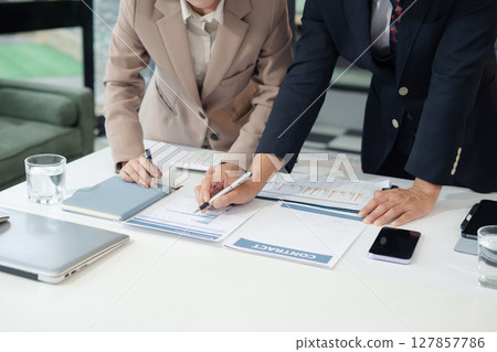 Business consultants discuss tax, merger strategy and restructuring in modern office. Business consultants discuss tax, merger strategy and restructuring in modern office. 127857786