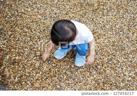 Toddler Playing with Pebbles Toddler Playing with Pebbles 127858217