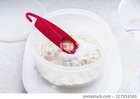 Bread making: Adding salt using a measuring spoon 127858300