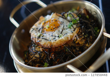 Korean Ramayan Noodle Stir Fry with sausage and topping with fried egg and dried seaweed 127858448