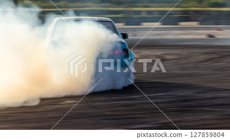 Car drifting, Blurred image diffusion race drift car with lots of smoke from burning tires on speed track, Car drifting on speed track. 127859804