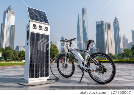 Modern Electric Bicycle Parked Beside Solar Charging Station in Urban Landscape with Skyscrapers Modern Electric Bicycle Parked Beside Solar Charging Station in Urban Landscape with Skyscrapers 127860007