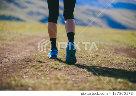 Fitness woman runner running at high altitude grassland mountain top road Fitness woman runner running at high altitude grassland mountain top road 127860178
