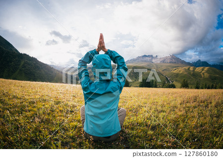 Woman hiker meditation on the high altitude mountain top grassland 127860180