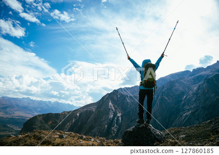 Backpacking woman hiking on high altitude mountain top 127860185