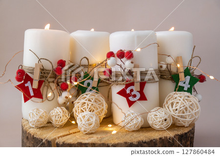 Traditional Burning Christmas Wax Candles with numbers counting down for Christmas Handmade Christmas countdown advent four-week calendar. Festive holiday preparation craft master class of creative 127860484