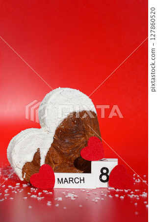 Women's day 8 March wooden calendar cubes wishes greeting holiday card Heartshaped pastry croissant treat topped with colorful frosting galore. Food experimentation viral dessert baking trend 127860520