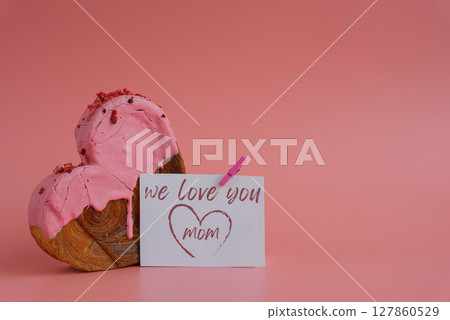 WE LOVE YOU MOM card Mother's Day holiday present Heart shaped strawberry berry croissant on pink background with copy space. Puff pastry new trendy sweet dessert bakery. Creamy dough WE LOVE YOU MOM card Mother's Day holiday present Heart shaped strawberry berry croissant on pink background with copy space. Puff pastry new trendy sweet dessert bakery. Creamy dough 127860529