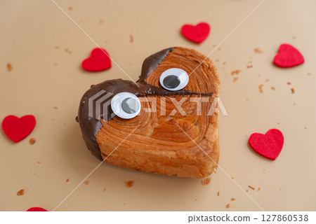 Funny food game face with crazy eyes April fool day joke Delightful and vibrant heartshaped pastry croissant treat, beautifully topped with colorful frosting galore. Food experimentation dessert Funny food game face with crazy eyes April fool day joke Delightful and vibrant heartshaped pastry croissant treat, beautifully topped with colorful frosting galore. Food experimentation dessert 127860538