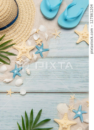 Summer accessories on blue wooden planks evoking beach holidays, relaxation and travel Summer accessories on blue wooden planks evoking beach holidays, relaxation and travel 127861204