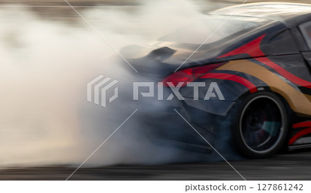 Car drifting, Blurred image diffusion race drift car with lots of smoke from burning tires on speed track, Car drifting on speed track, Professional driver driv drifting car. 127861242