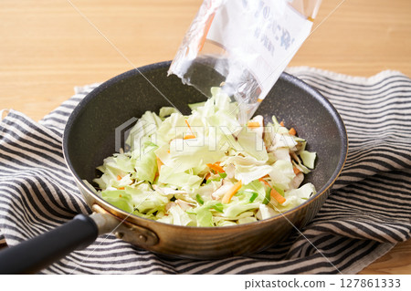Cut vegetables in a frying pan (cabbage, mushrooms, carrots) 127861333