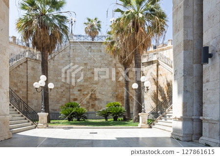 Historic stone courtyard with palm trees and vintage lampposts in Barcelona Spain 127861615