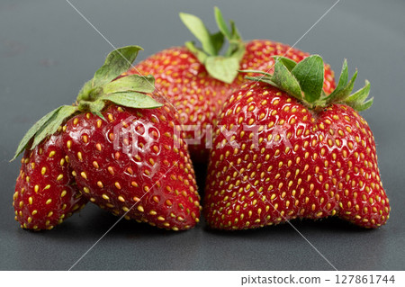 Fresh strawberries with an unusual shape close-up Fresh strawberries with an unusual shape close-up 127861744