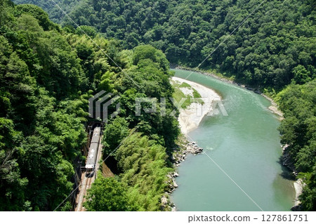 Limited Express Inaji (373 series) running along the Tenryu River with its fresh greenery Limited Express Inaji (373 series) running along the Tenryu River with its fresh greenery 127861751