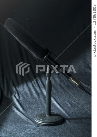 Studio microphone for podcasting or streaming with a black background 127861808