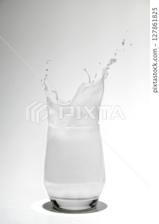 Milk in a glass with a splash on a white background Milk in a glass with a splash on a white background 127861825