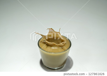 Caramel in a glass with a splash on a white background Caramel in a glass with a splash on a white background 127861826