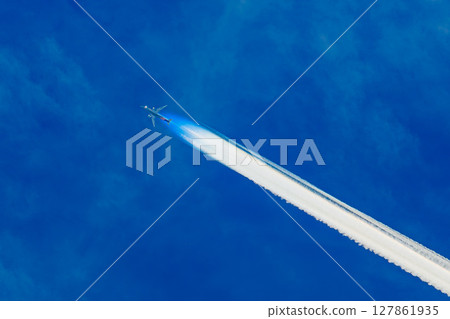一架飛機劃破藍天，留下一道閃亮的尾跡 127861935
