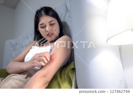 Indonesian southeast asian woman suffering from skin allergy, scratching her itchy and rash skin with her fingers. Healthcare concept Indonesian southeast asian woman suffering from skin allergy, scratching her itchy and rash skin with her fingers. Healthcare concept 127862799