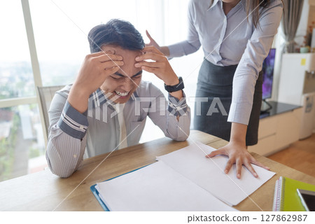 Indonesian southeast asian businessman gets scolded by his boss for being late or for the stress of deadlines. Paperwork on the table. Business concept Indonesian southeast asian businessman gets scolded by his boss for being late or for the stress of deadlines. Paperwork on the table. Business concept 127862987