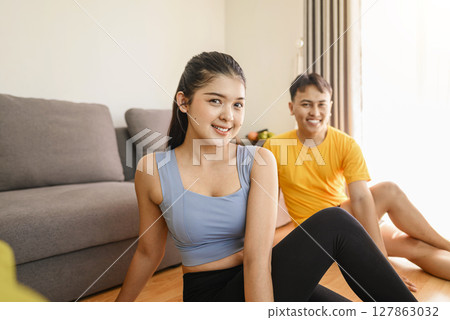 Indonesian southeast asian couple stretching before a workout at home for a healthy lifestyle and body care. Fitness and active lifestyles concept Indonesian southeast asian couple stretching before a workout at home for a healthy lifestyle and body care. Fitness and active lifestyles concept 127863032