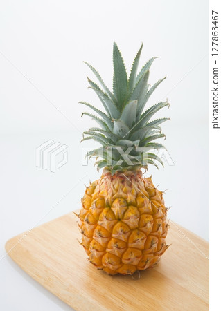 Pineapple on a wooden cutting board Pineapple on a wooden cutting board 127863467